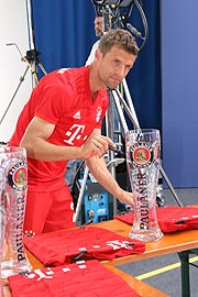 Thomas Müller beim signieren von Weißbiergläsern und Trikots nach dem Fotoshooting (©Foto: Martin Schmitz)